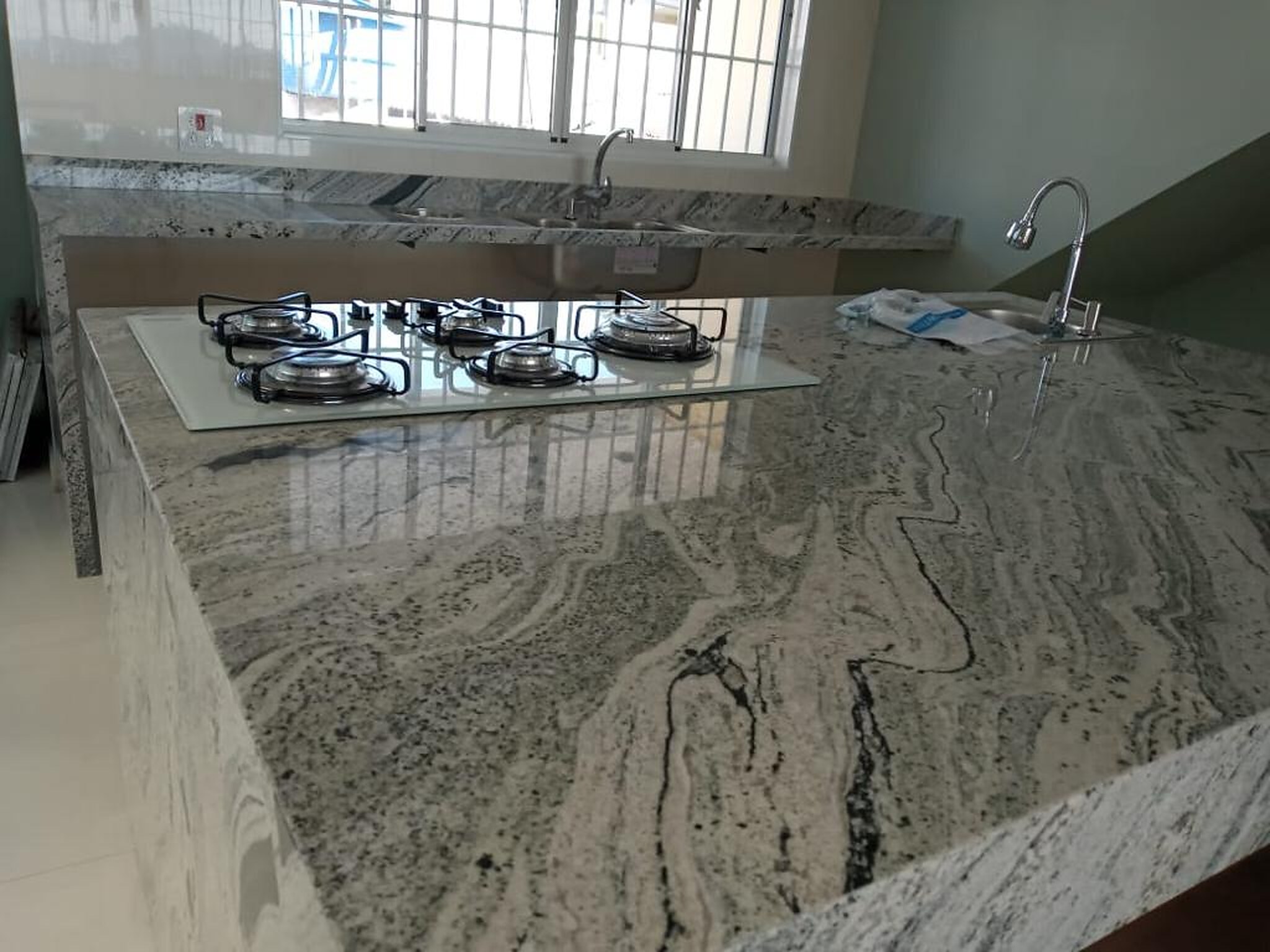 cozinha planejada com pedra clara e bancada sob medida